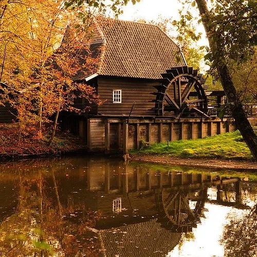 De Genneper Watermolen aan het water, omringd door bomen